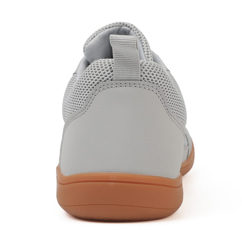 gray fly knit wide last sneaker with breathable mesh upper, gum-colored rubber sole, and subtle pull tab at the heel shown from the back side