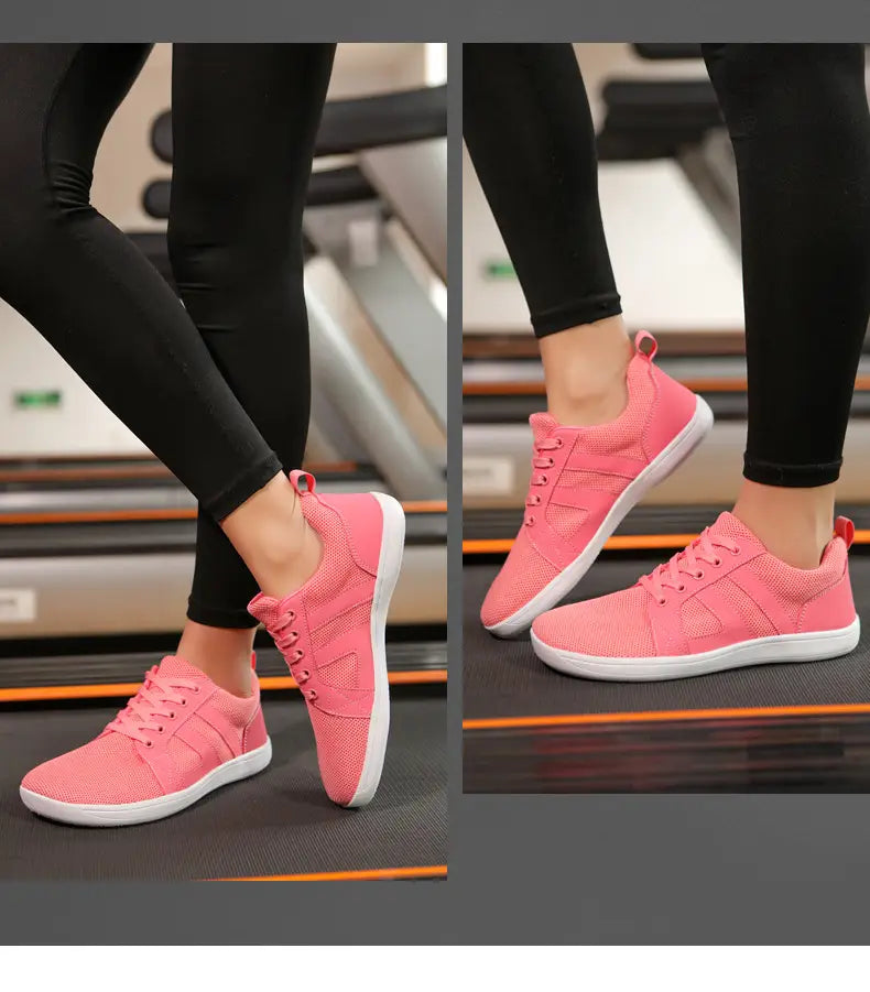 pink fly-knit wide last sneakers with breathable mesh material featuring white soles and laces for athletic use