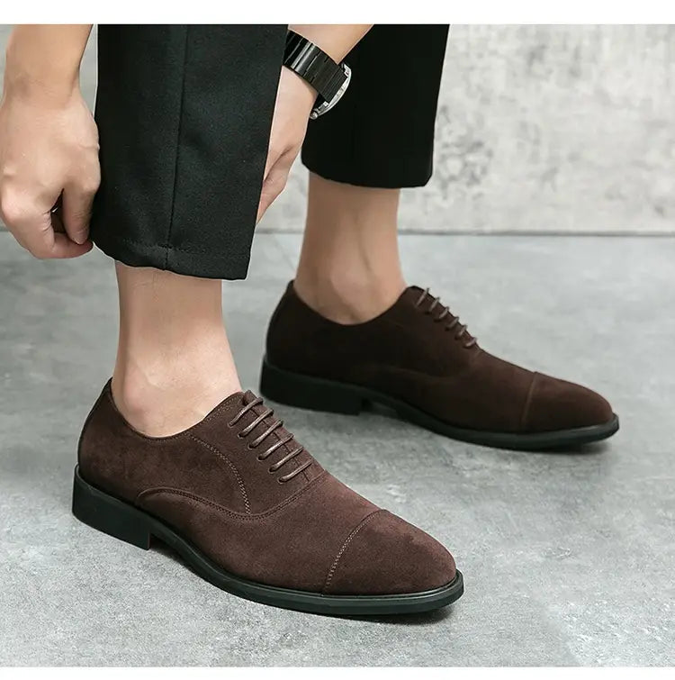 Modern suede business casual oxford shoes in black suede with cap toe lace-up design and stitched detailing.