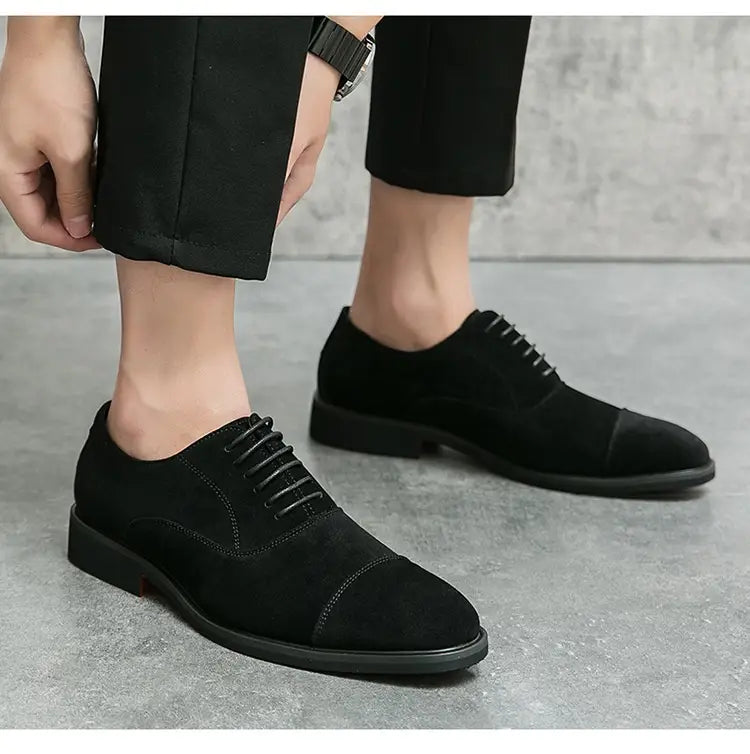 Modern suede business casual oxford shoes in black suede with cap toe lace-up design and stitched detailing.