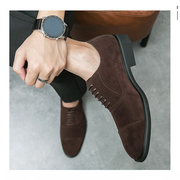 Modern suede business casual oxford shoes in black suede with cap toe lace-up design and stitched detailing.