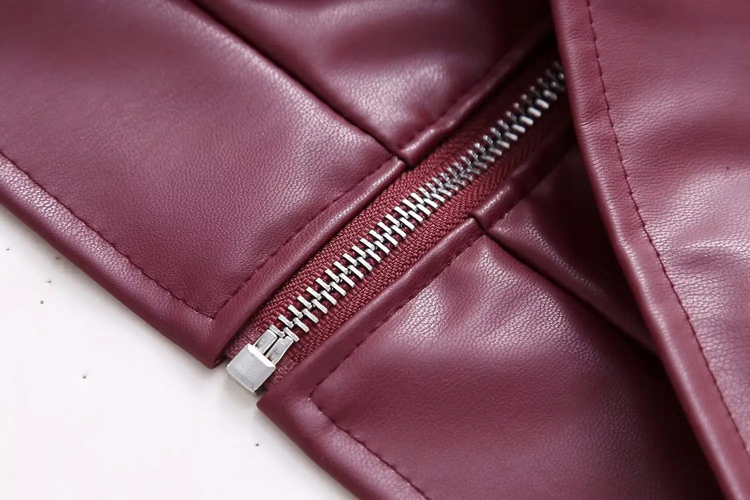 Maroon faux leather biker jacket for women featuring a silver zipper on the front.
