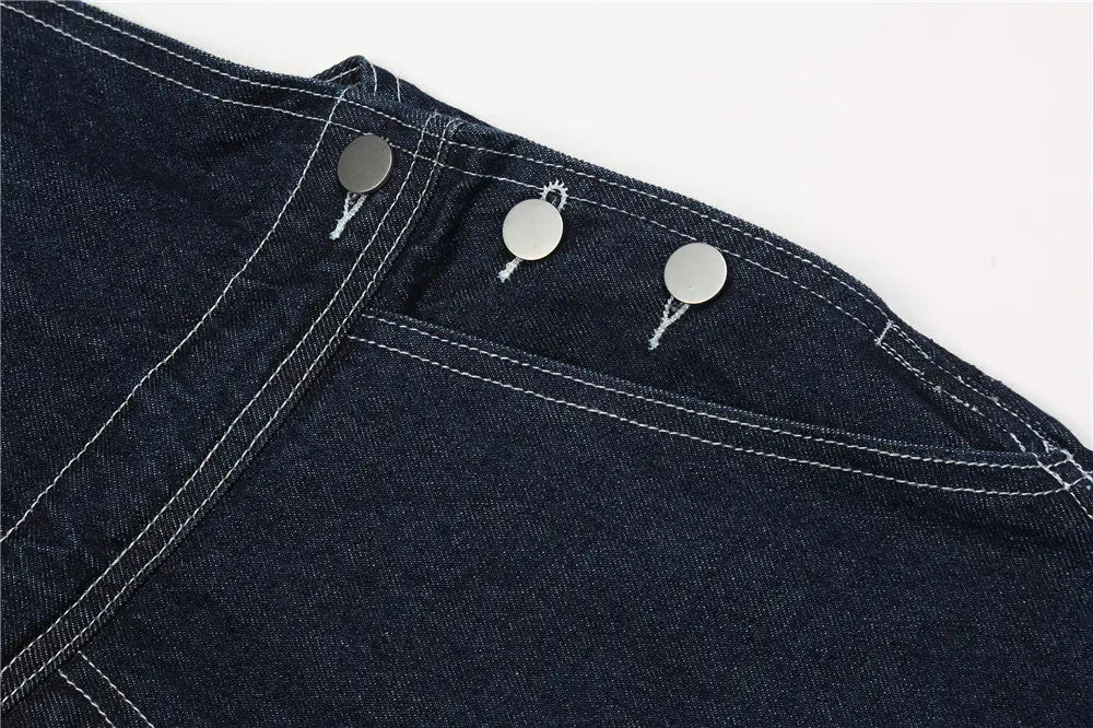 Herren bestickte dunkelblaue Jeanslatzhose mit dunkelblauem Jeansstoff, drei silbern wirkenden Metallknöpfen und kontrastierender weißer Ziersteppung.