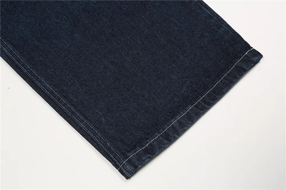 Herren bestickte dunkelblaue Jeanslatzhose mit dunkelindigofarbenem Stoff und kontrastierender weißer Ziersteppung entlang des Saums.