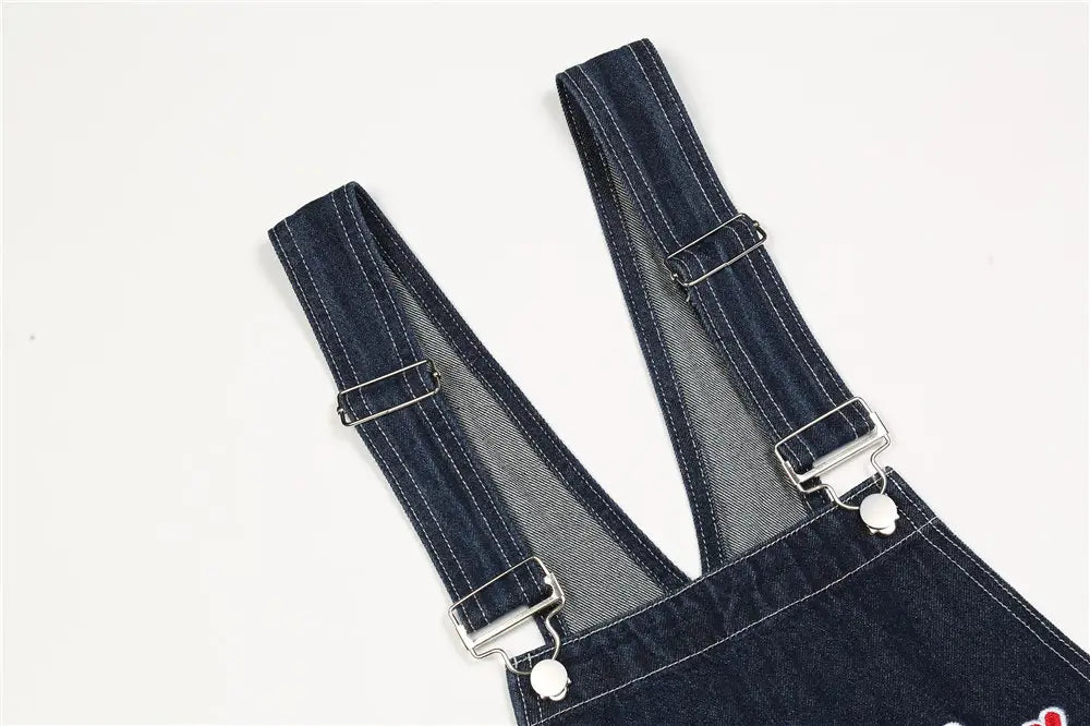 Herren bestickte dunkelblaue Jeanslatzhose mit silbern wirkenden Metallverschlüssen und verstellbaren Trägern.