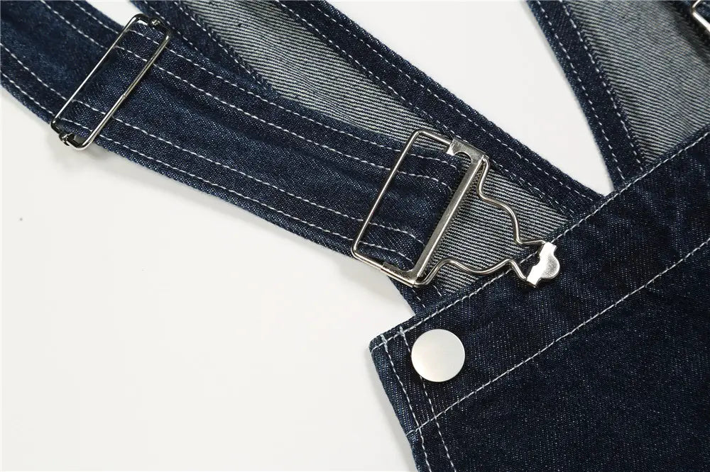 Herren bestickte dunkelblaue Jeanslatzhose mit silbern wirkenden Metallverschlüssen und weißer Ziersteppung.