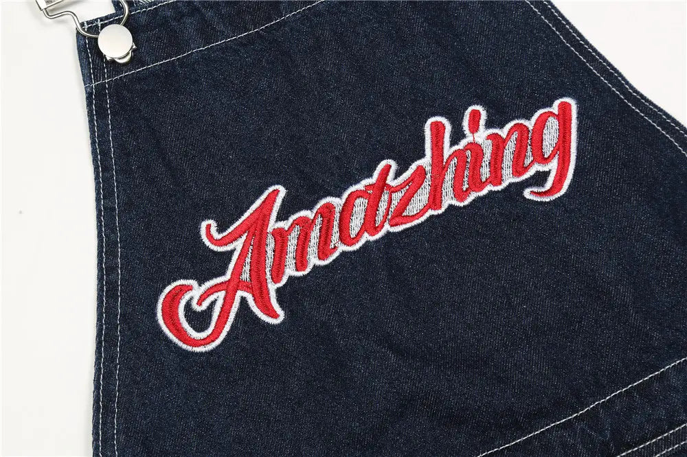 Herren bestickte dunkelblaue Jeanslatzhose mit auffälliger rot-weißer bestickter Amazzing-Schrift über der Vorderseite.