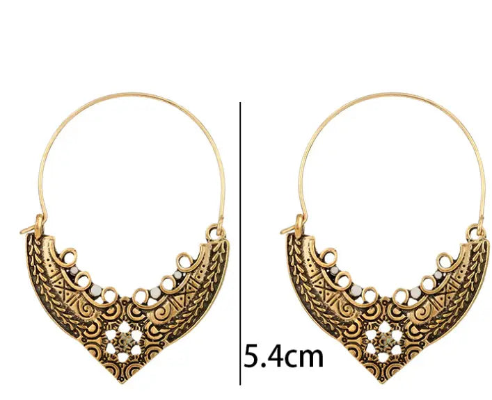 goldfarbene Creolen mit kunstvollen, ornamentalen Filigran-Designs und kleinen weißen Perlen entlang der geschwungenen Kante in silberfarbenen Filigran-Mandala-Creolen im Crescent-Stil.