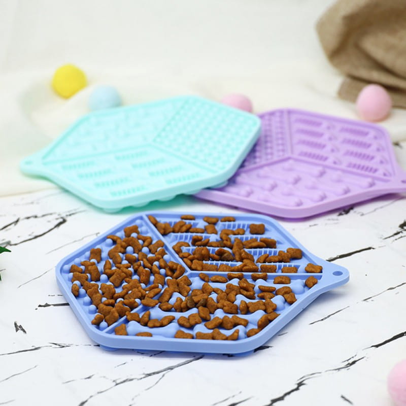 Blaues sechseckiges Silikon-Geduld-„Dog Lick“-Mattenpuzzle als Futterunterlage mit braunem Trockenfutter gefüllt für eine interaktive Tierfütterung.