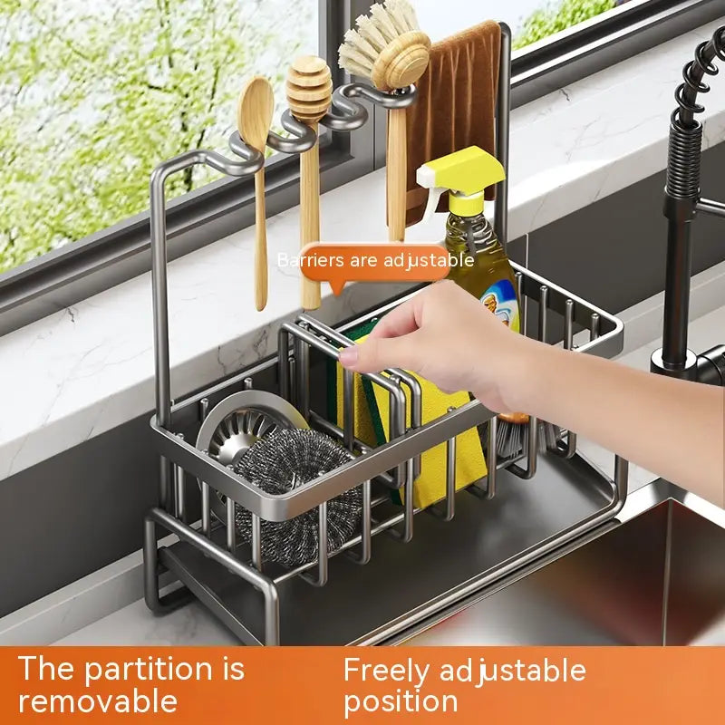 Stainless steel kitchen sink storage rack organizer with adjustable removable partition holding utensils scrubbers and cleaning spray.