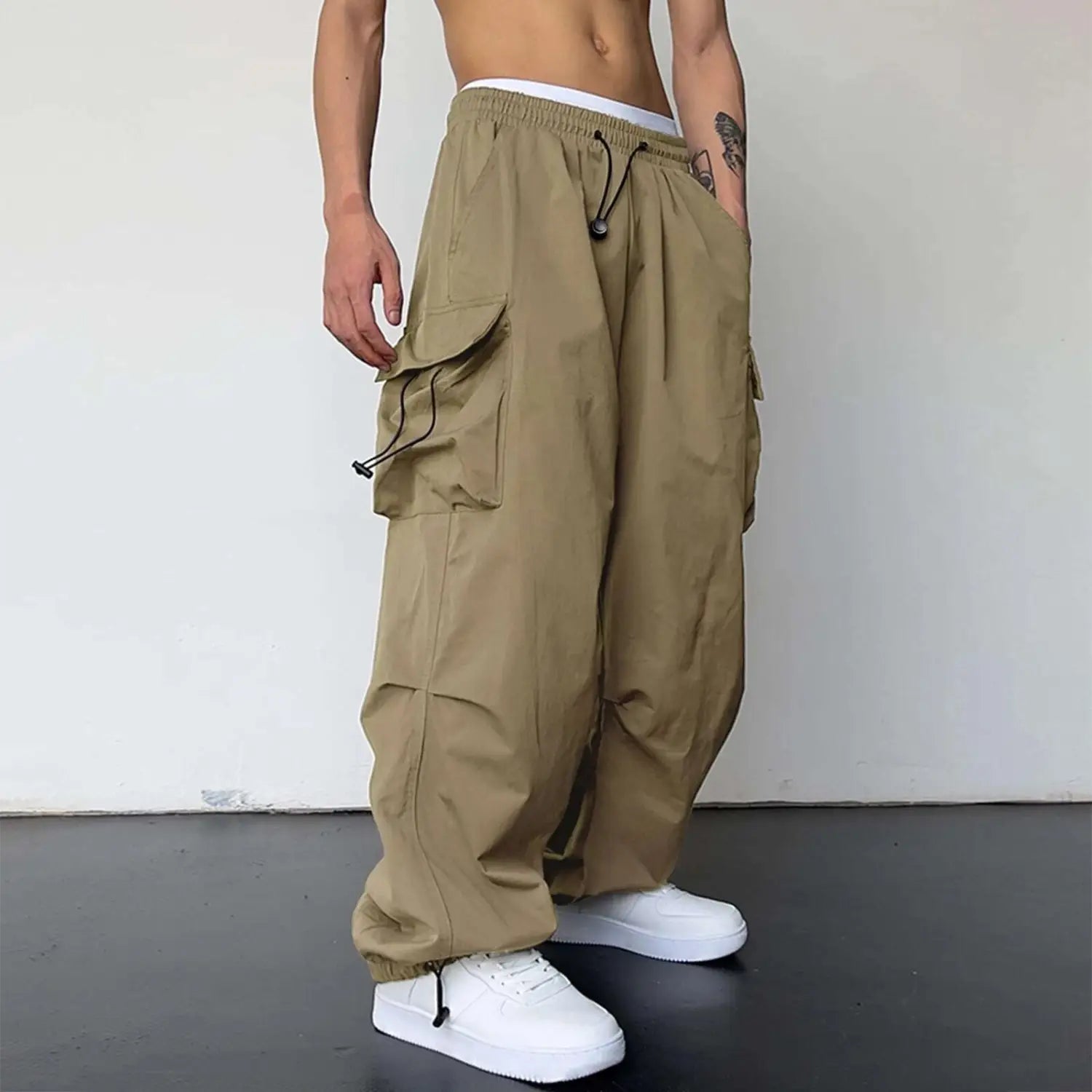 pantalon cargo beige kaki à séchage rapide pour hommes, avec de multiples poches latérales et une taille à cordon de serrage à jambe ample, présenté de face.