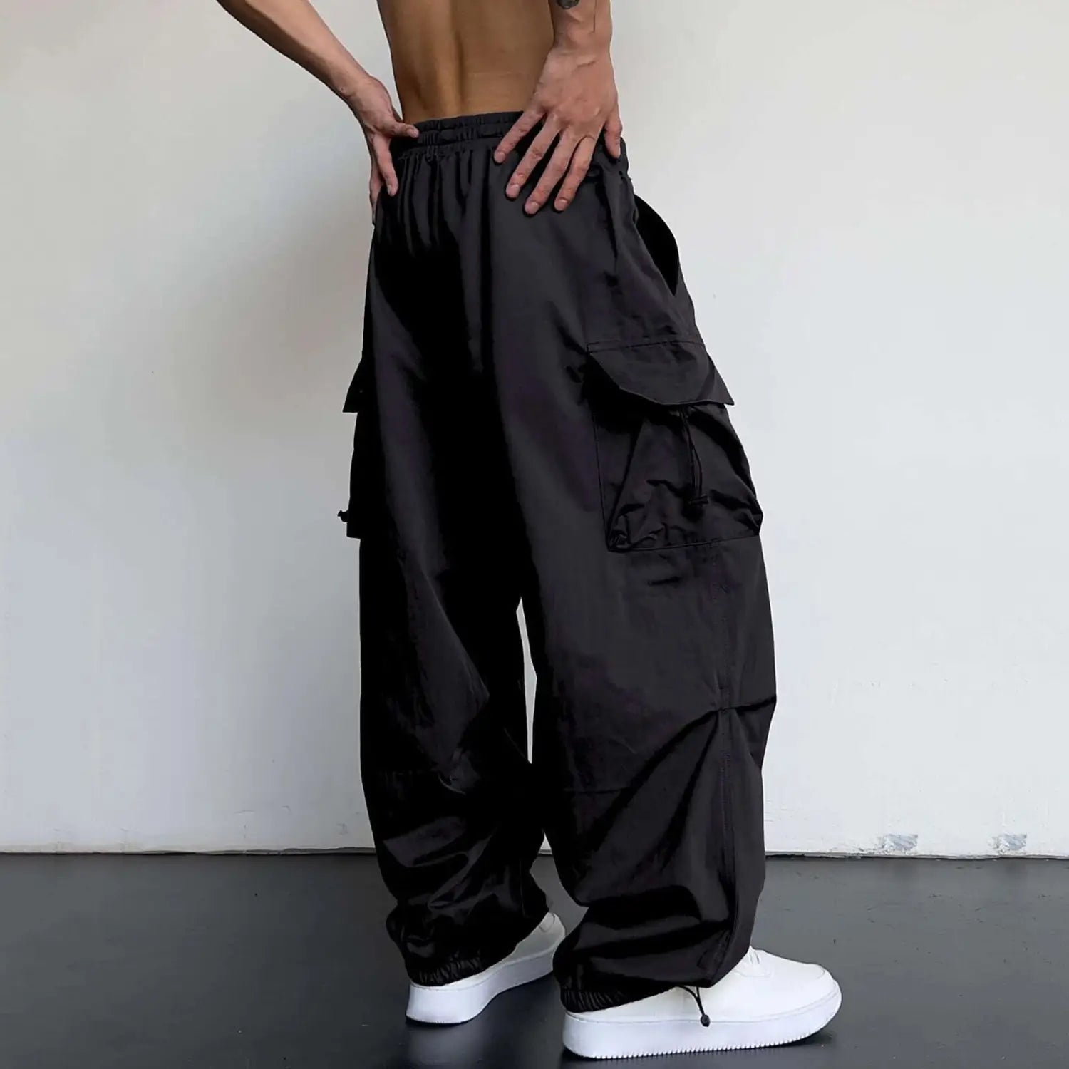 les pantalons cargo noirs à séchage rapide pour hommes présentent une coupe à jambe ample, avec de nombreuses poches et une taille élastique à cordon de serrage, conçue pour le confort et l’utilité.
