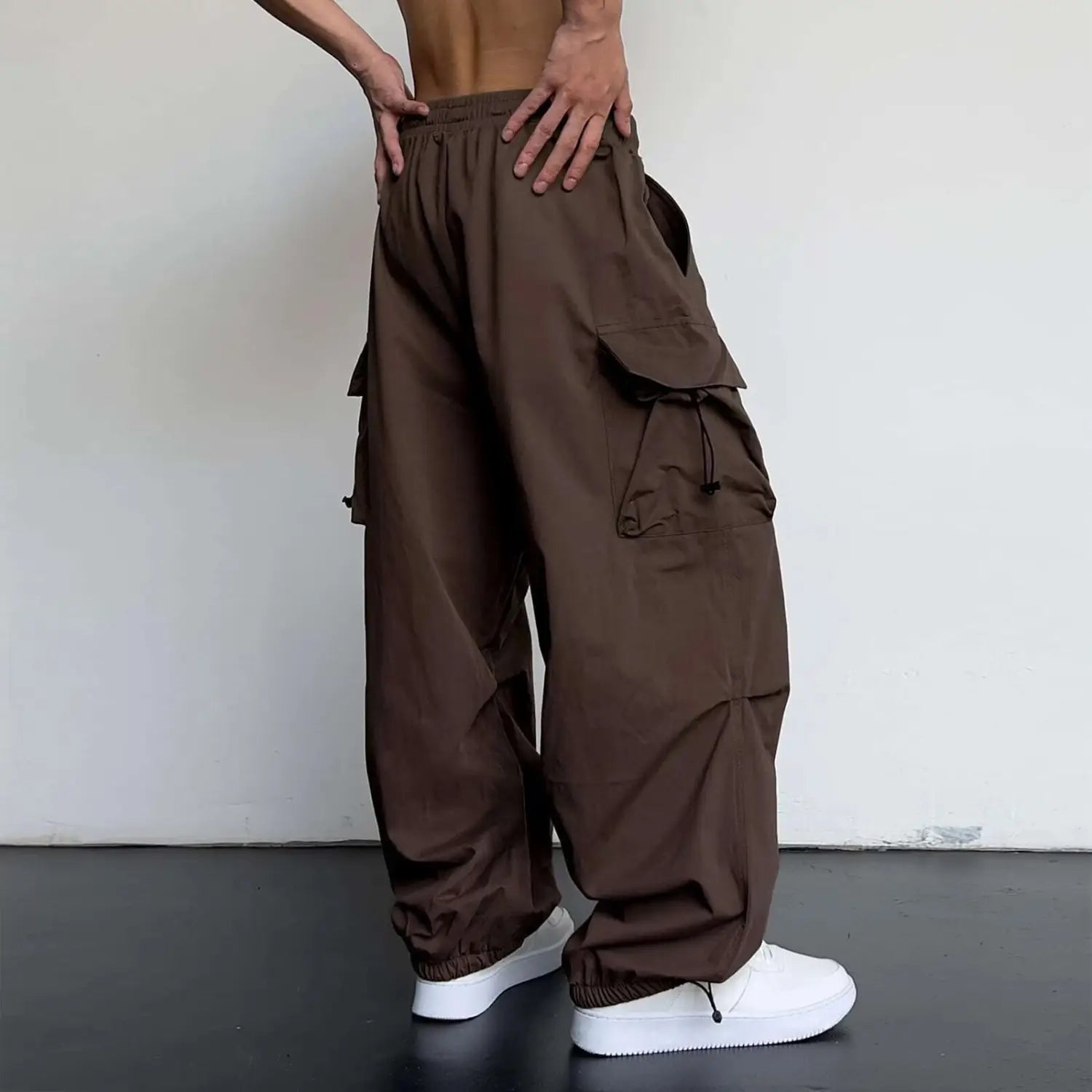 pantalon cargo marron à séchage rapide pour hommes, coupe à jambe ample, avec de multiples poches et des détails de cordon de serrage affichés de face.