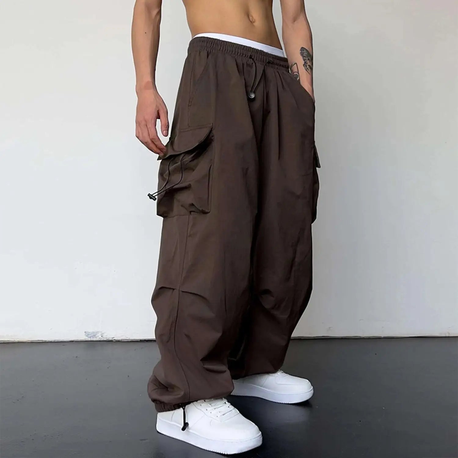 Pantalon cargo marron à séchage rapide pour hommes, coupe à jambe ample, avec de multiples poches et une taille élastique à cordon de serrage.