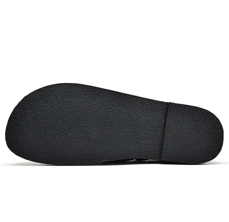 Semelle en caoutchouc noir avec surface gaufrée à relief de type pierre et une couture centrale discrète de mocassins décontractés en cuir pour hommes à enfiler avec boucle.
