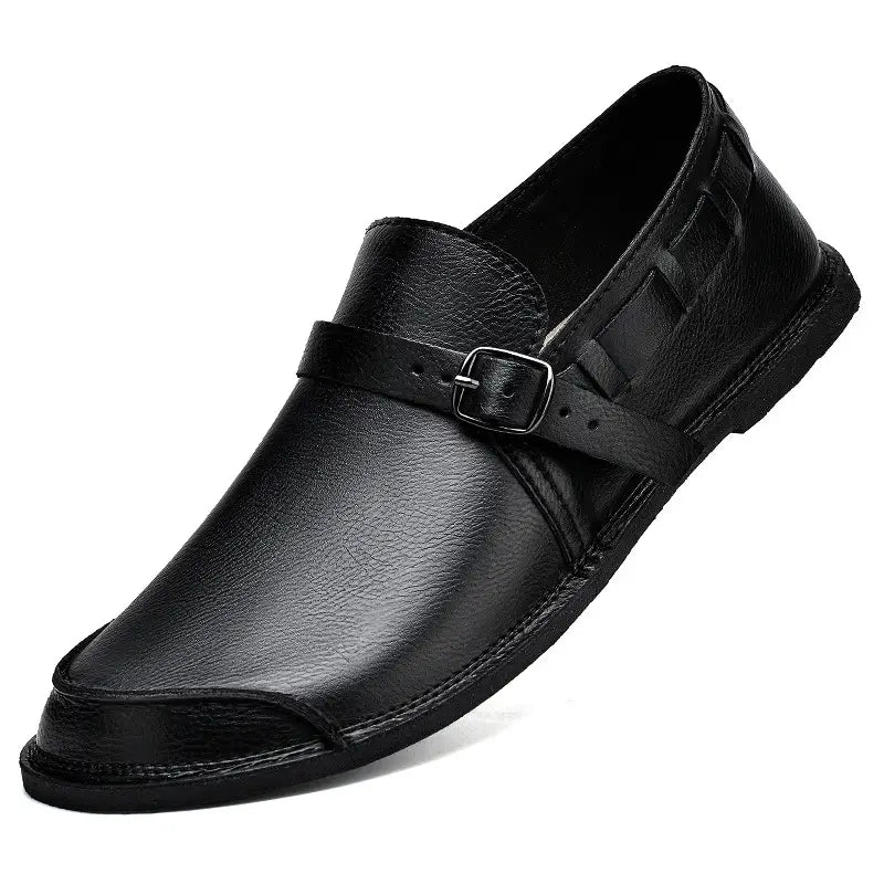 Mocassin à enfiler en cuir noir pour hommes, avec une seule sangle et une boucle argentée, conçu comme une chaussure décontractée.