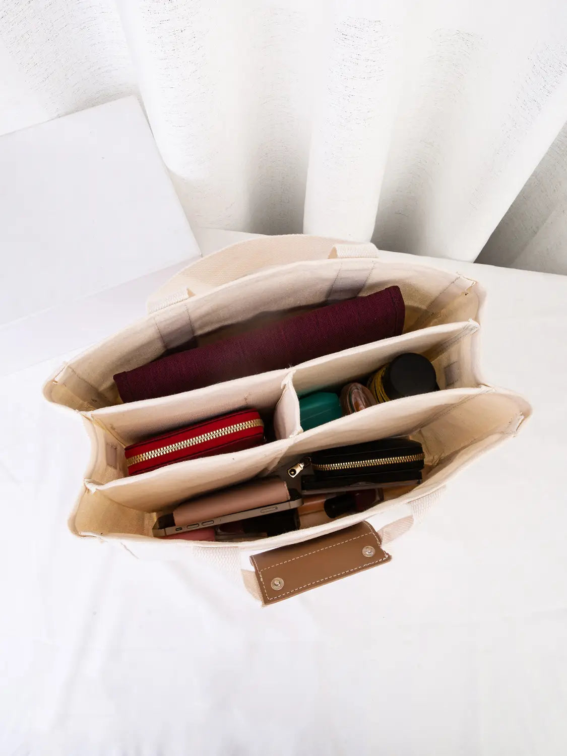 Beige canvas messenger bag mother and baby travel tote with multiple compartments and brown leather tag.