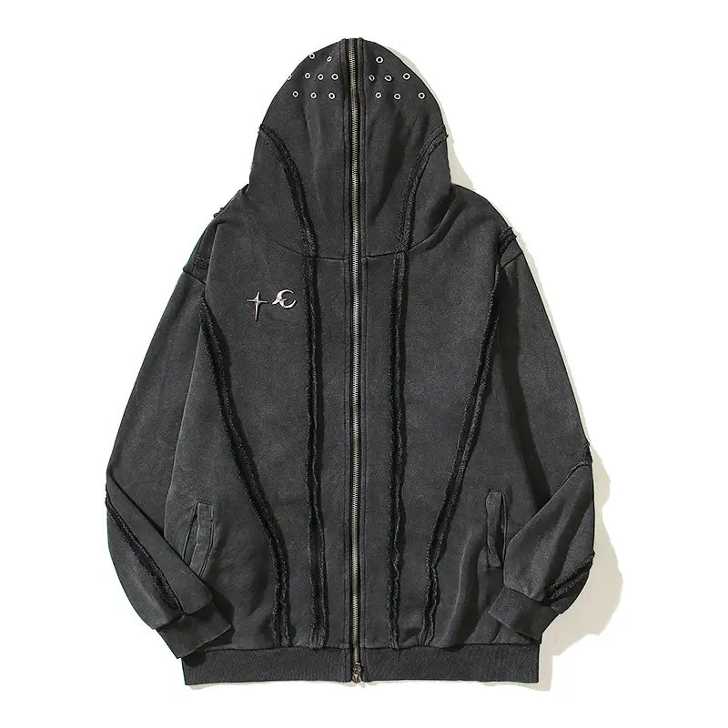 Sudadera con cremallera y capucha estilo batik desgastado en color negro, con ojales plateados a lo largo de la capucha y la cremallera frontal, y un sutil diseño de cruz y media luna bordado en el lado izquierdo del pecho.