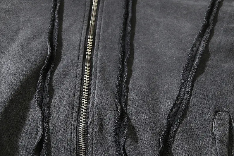 Cárdigan con capucha estilo batik desgastado color gris oscuro, con cordones negros deshilachados y una cremallera metálica.