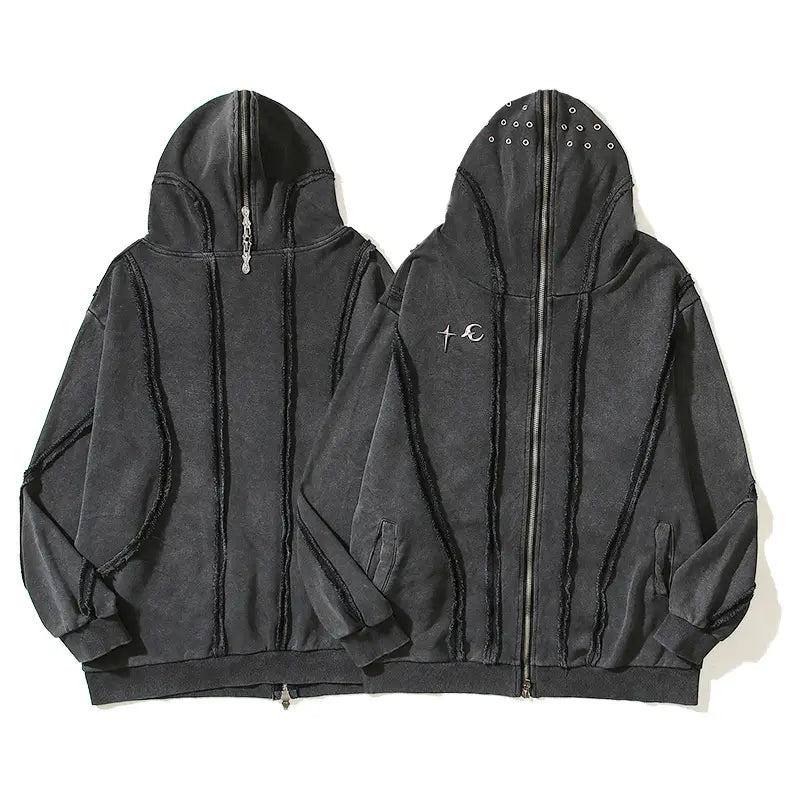 Sudadera negra tipo hoodie con cremallera y capucha, con costuras deshilachadas y bordado sutil de cruz y círculo en el pecho, diseñada como cárdigan con cremallera y capucha estilo batik.