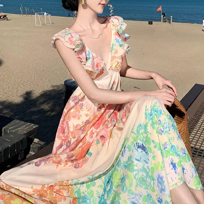 A flowing French Floral v Neck ruffle maxi dress with floral print, ruffled shoulder straps, and a gradient of soft pastel hues from peach to mint green.