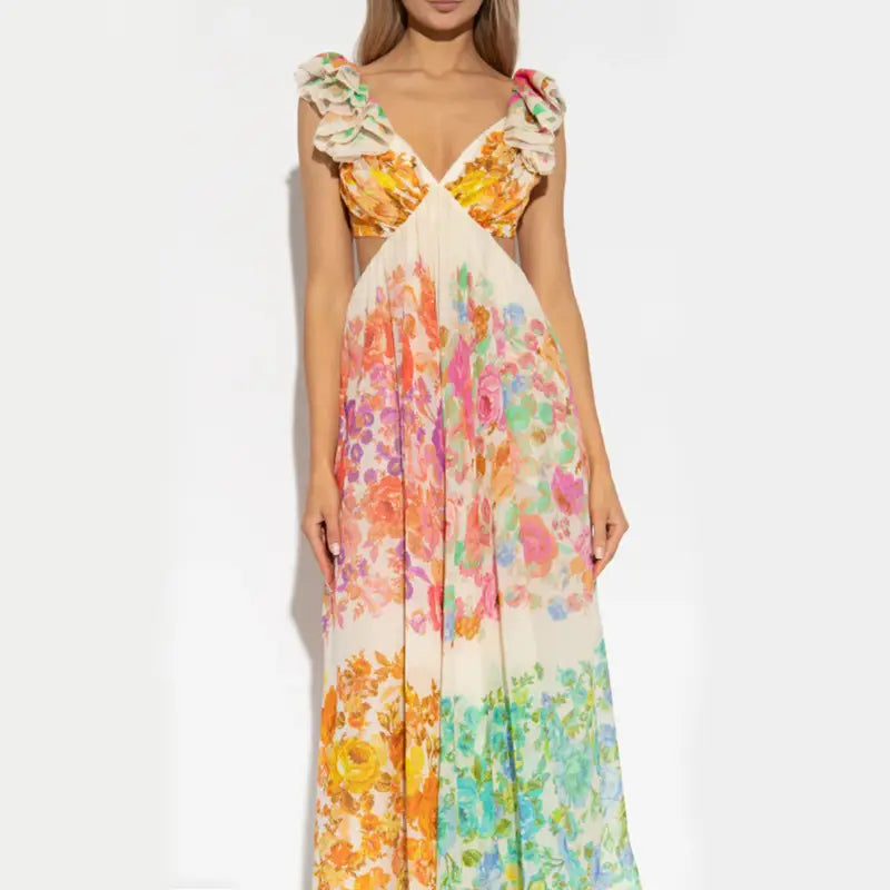 A flowing long-sleeved French floral v neck ruffle maxi dress with a vibrant watercolor floral pattern in shades of orange pink green and yellow.