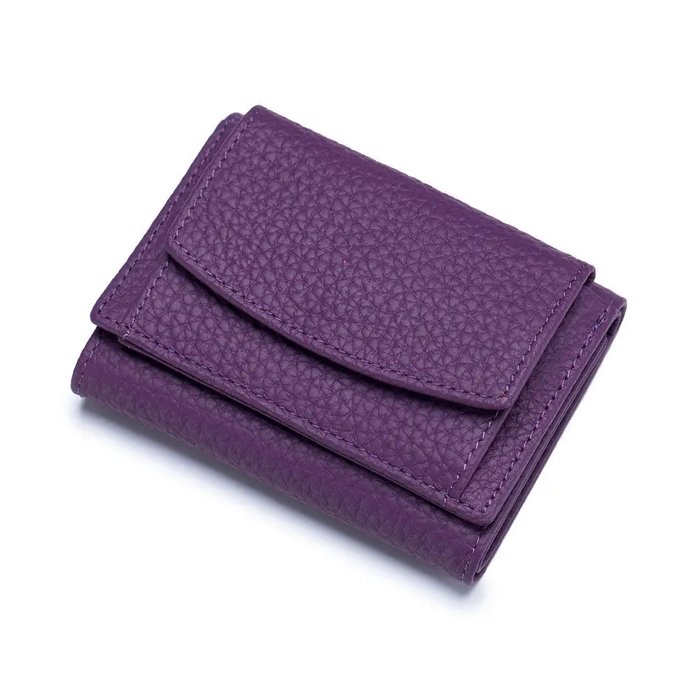 Purple textured leather trifolled mini wallet with visible stitching made of compact cowhide for bifold card holding.