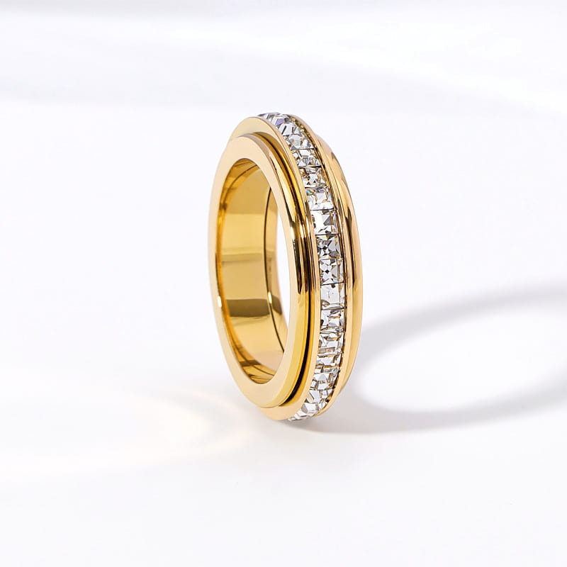 Gold-colored rotating square diamond titanium steel ring featuring a central band of clear rectangular-cut stones in a sleek modern design.