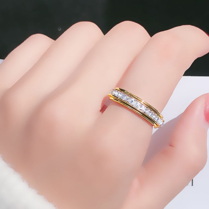 Gold band rotating square diamond titanium steel ring with a central row of clear faceted stones set in an elegant multi-layered design