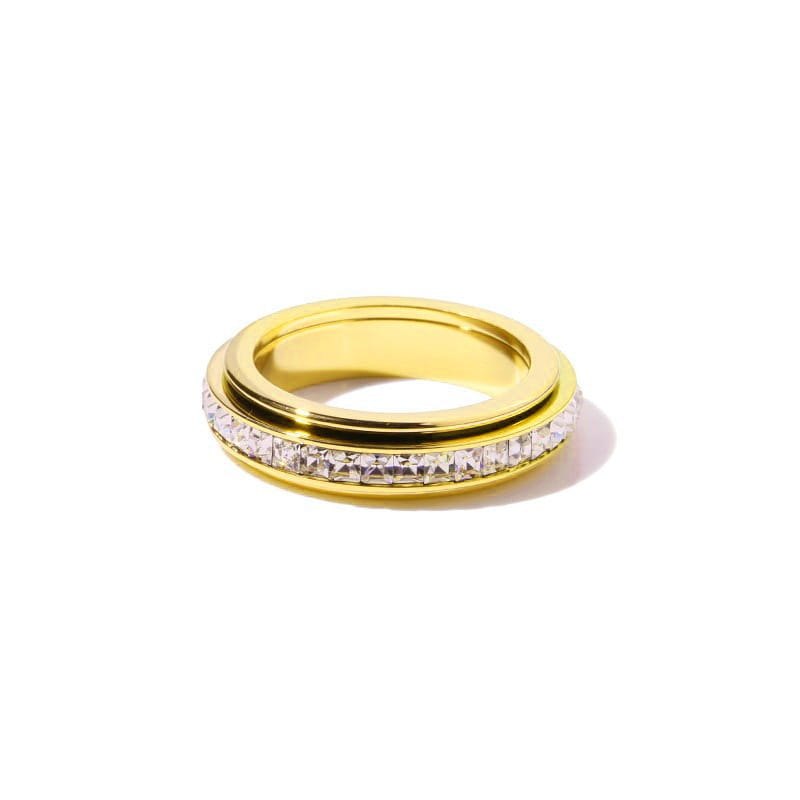 Gold-toned rotating square diamond titanium steel ring with sleek two-tier design and central band of clear faceted crystals set in polished metallic frame.