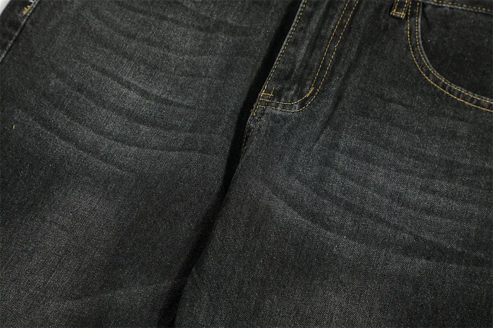 Vaqueros de mezclilla de algodón para hombre con campana desgastada y lavado oscuro, con costuras amarillas claras en contraste a lo largo de las costuras y los bordes de los bolsillos.