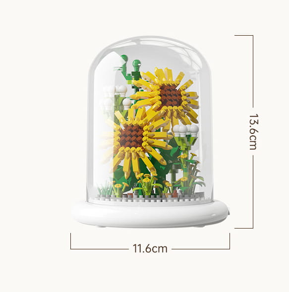 Une coupole en verre transparente renfermant un modèle LEGO détaillé de deux tournesols jaunes vibrants avec des tiges et des feuilles vertes sur une base blanche, comme décoration jouet de dôme en verre pour fleurs, bloc de construction, éclairage LED.