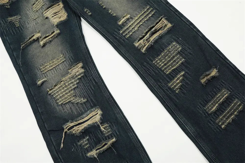 Jeans déchirés homme à effet usé, jambe droite, en denim, comportant plusieurs zones de déchirure effilochées avec coutures visibles et bords bruts.