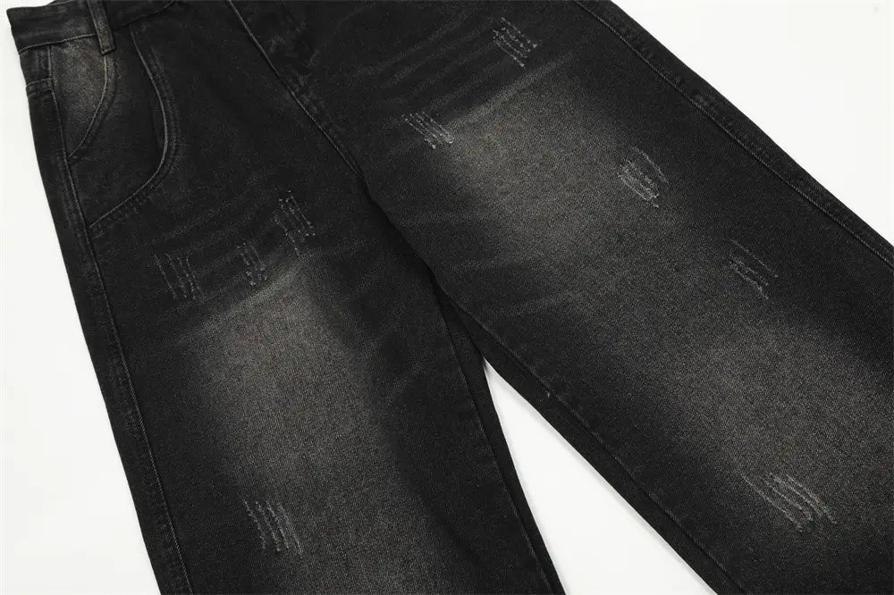 Vaqueros negros de mezclilla con pernera recta y estilo desgastado para hombre, con parches deslavados y estarcido sutil tipo «whiskering» en un estilo desgastado.