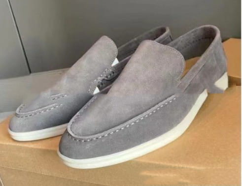 Mocasines de ante para hombre en color gris con suelas de goma blancas y costuras contrastantes, diseñados para uso casual.