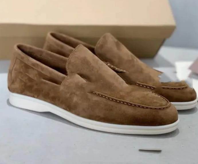 Mocasines de ante marrón para hombre con suela de goma blanca y costuras contrastantes para uso casual.