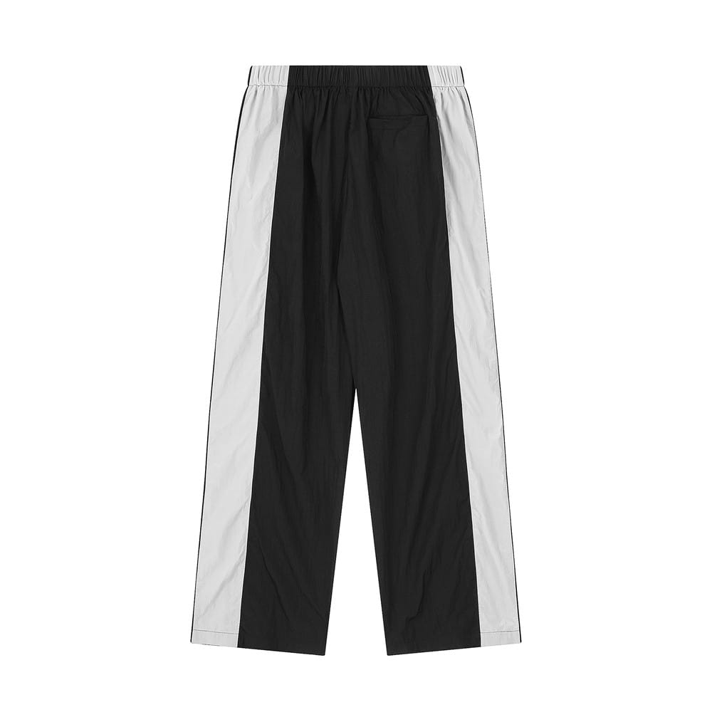 Joggers de mezclilla para hombre con panel de contraste y cintura elástica en negro y tela a rayas laterales en blanco, con cintura elástica.
