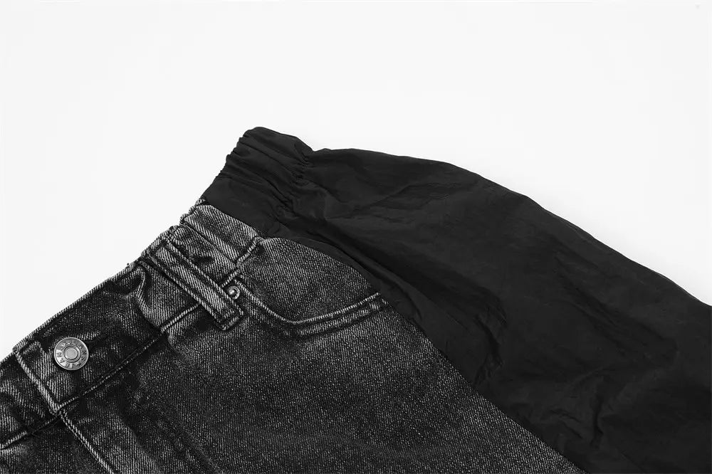 Joggers de mezclilla negros para hombre con panel a contraste, cinturón con cordón elástico y cierre de botón plateado.
