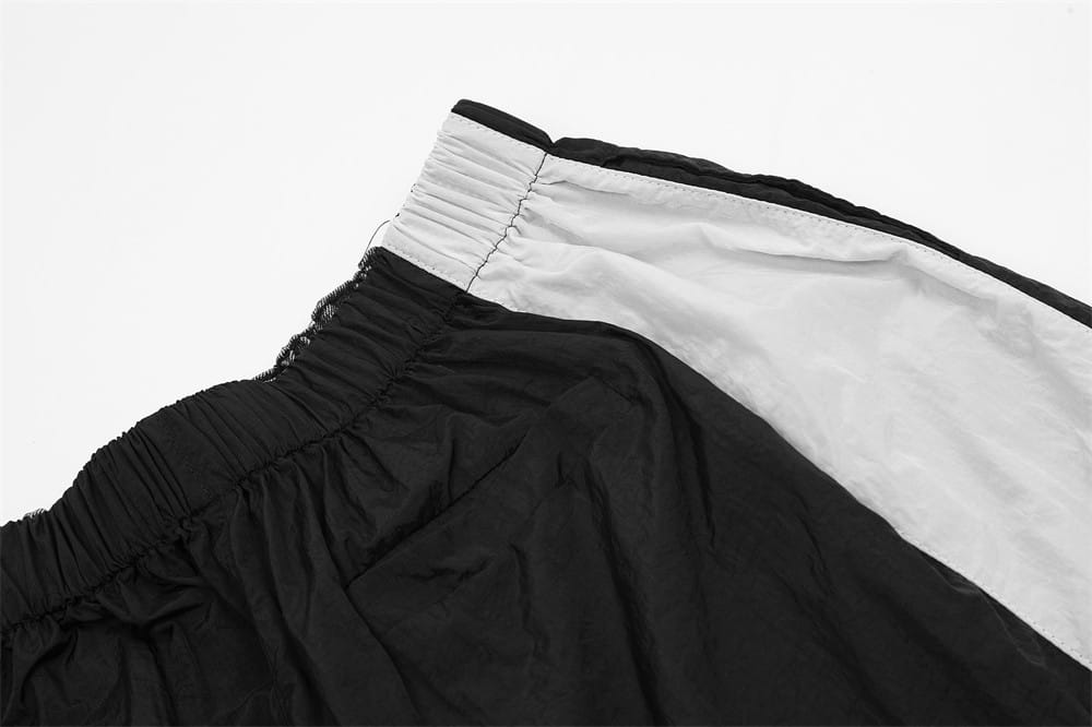 Joggers de mezclilla para hombre con panel de contraste y cintura elástica, que presentan shorts atléticos negros y blancos con cinturón con cordón.