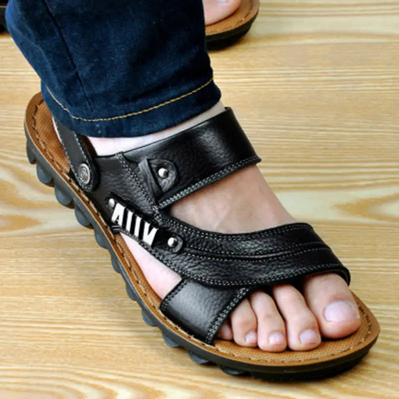 Men’s cowhide leather sandals in black featuring adjustable straps with silver-toned buckle accents and a textured sole.