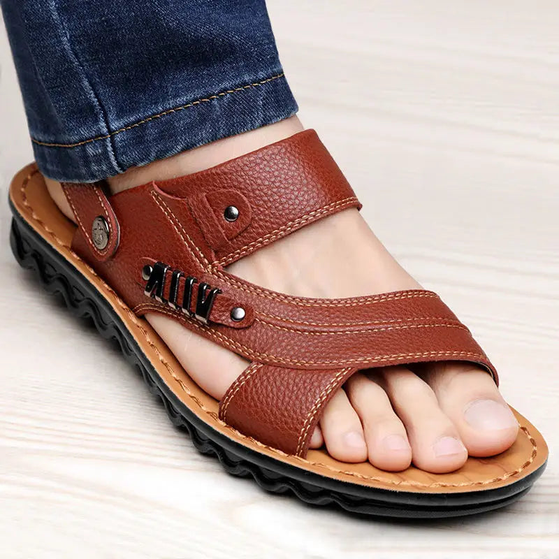 Men’s cowhide leather sandals featuring brown textured leather with buckle accents, black rubber sole, and tan stitching.