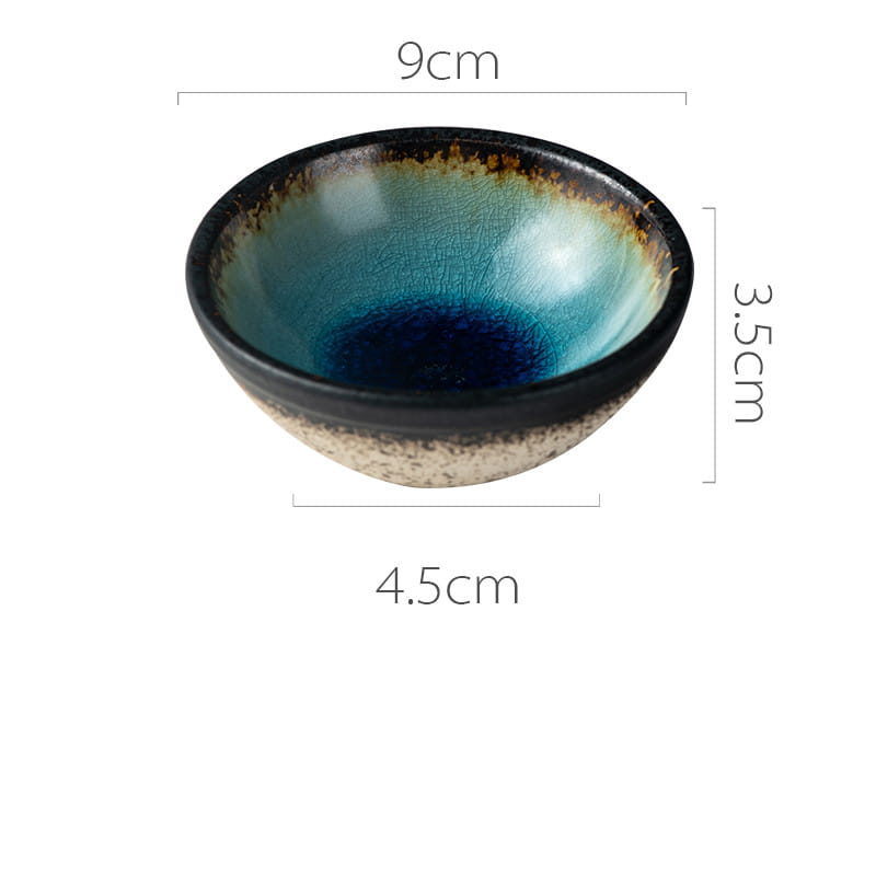 A handcrafted Japanese ceramic small plate with a rustic speckled glaze featuring a gradient from deep blue to teal, a speckled beige base, and a dark rim.