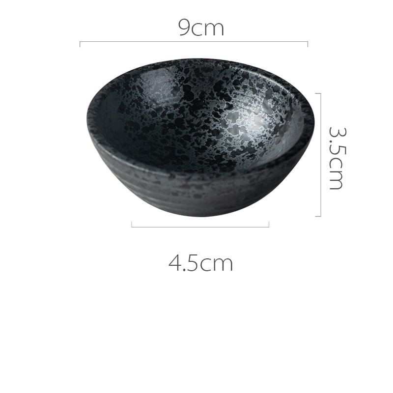 A sleek dark gray ceramic small plate with a rustic speckled glaze and subtle concentric ridges in Japanese style.