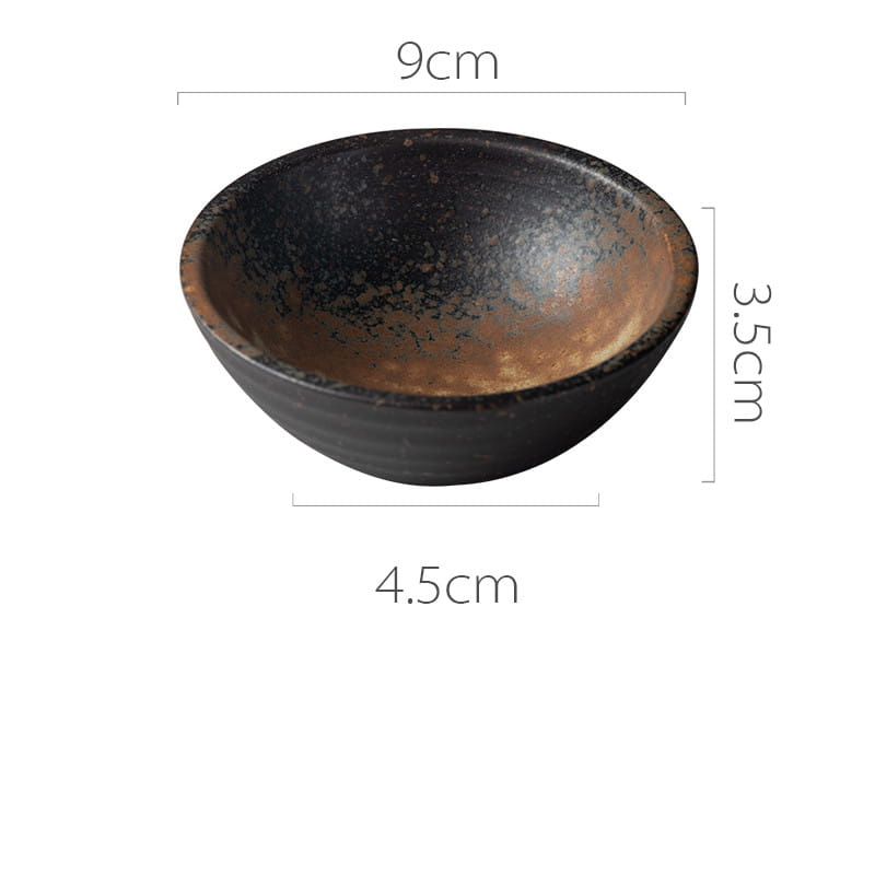 A rustic black ceramic small plate with a speckled earthy interior and subtle brown glaze accents featured in Japanese ceramic small plates rustic speckled glaze.