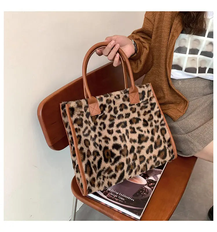 Large capacity leopard print plush tote bag with brown and white cow print faux fur and tan leather handles.