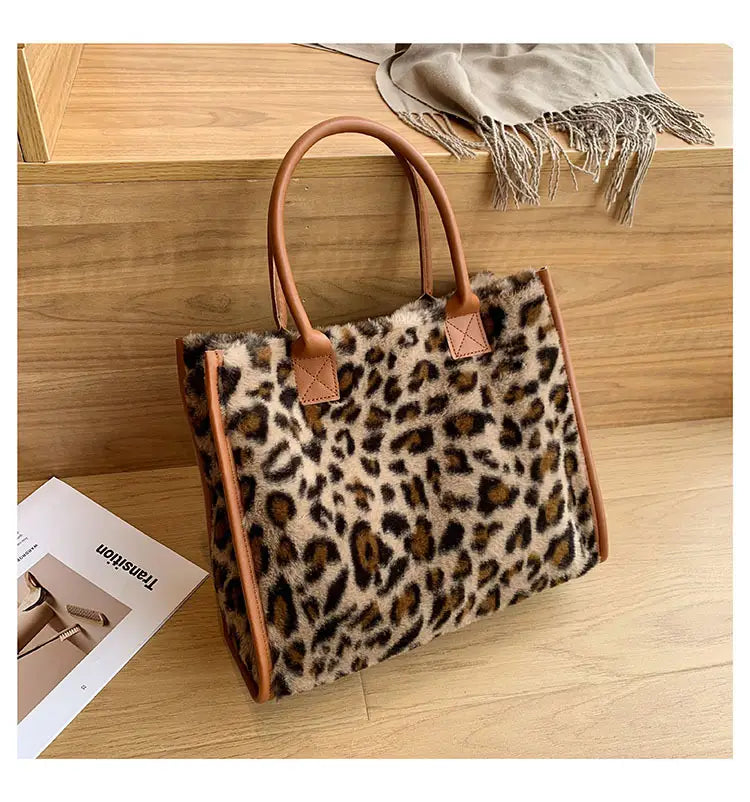 Large capacity leopard print plush tote bag with brown and white cow print faux fur and tan leather handles.