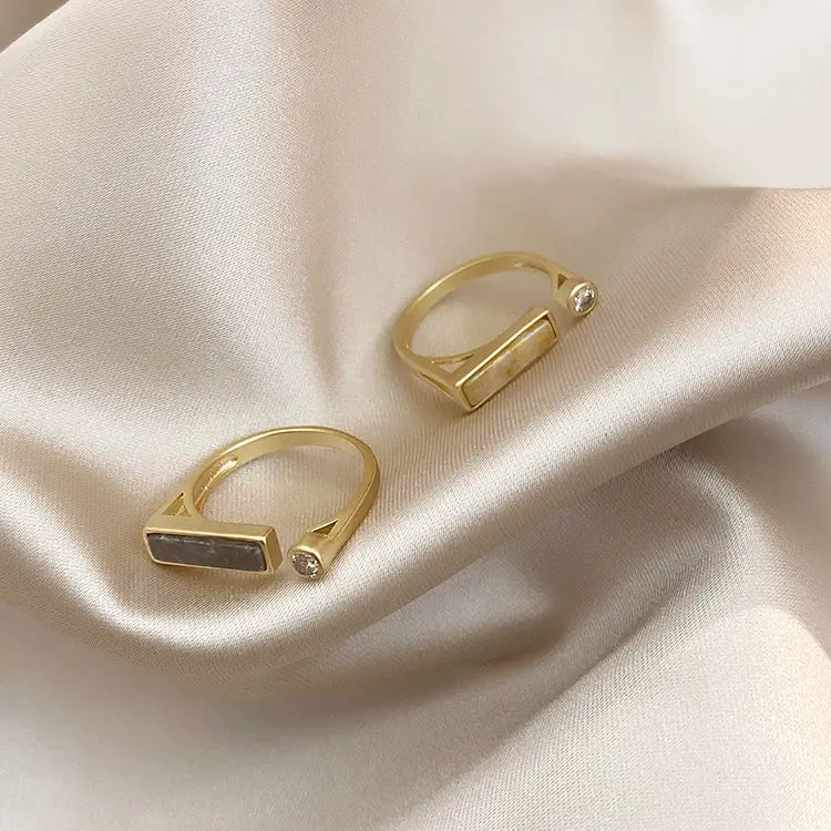Gold-toned vintage geometric zircon marble adjustable rings with rectangular open-backed designs and small clear gemstones on the sides.