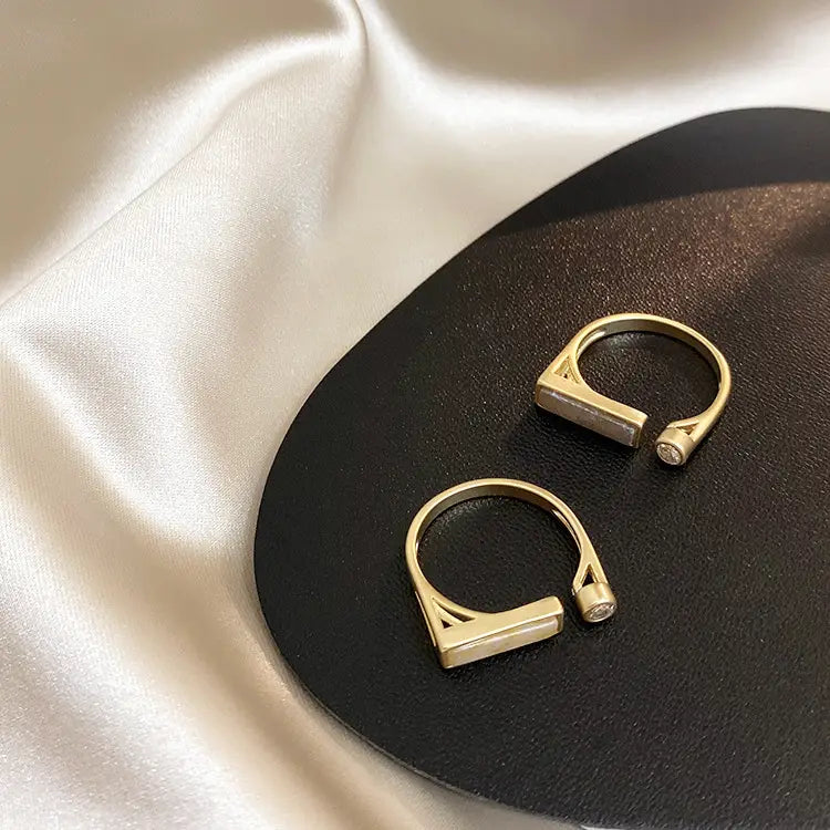 Gold-toned vintage geometric adjustable ring with triangular design and small clear zircon stone accent.