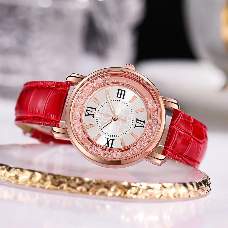 A rose gold quicksand crystal watch with a red crocodile-patterned embossed leather strap and a sparkling crystal-encrusted bezel.