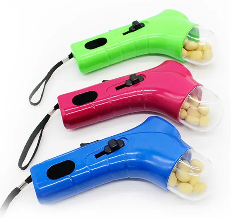 Jouet pour friandises pour chien, lanceur portatif pour friandises pour animaux, en plastique aux couleurs vives vert, rose et bleu, avec compartiments transparents contenant des friandises jaunes.
